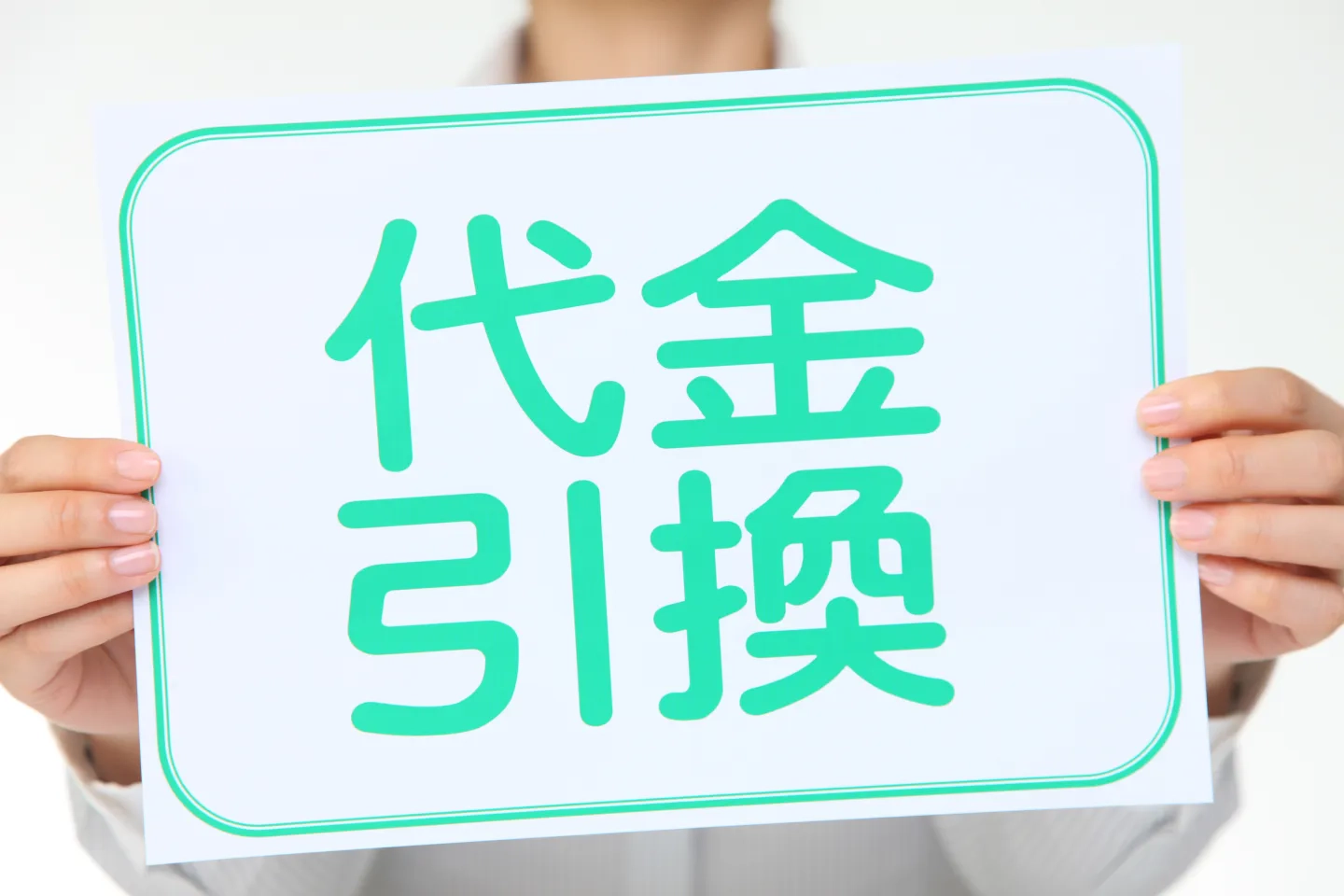 代金引換と記載されているパネルを持った人の写真